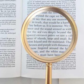 large metal and glass lens reading magnifier magnifying book text 